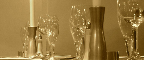 Gedeckter Tisch mit Kerzen und Gläsern (Sepia)